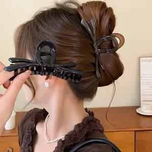 Vista detallada de una pinza para el pelo negra con forma de lazo sujetando un moño
