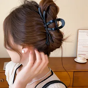 Vista detallada de una elegante pinza para el pelo de mariposa negra en un moño.