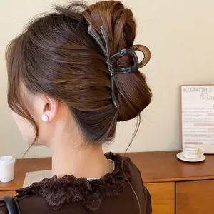 Detalle de una pinza para el pelo con lazo marrón oscuro en un peinado recogido elegante