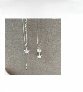 Detalle de collares con colgante de estrella en plata mate y elegantes cuentas de perlas