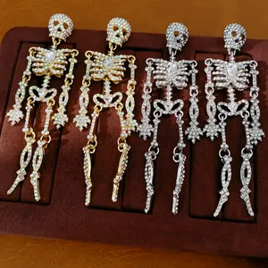 Detailansicht von kristallbesetzten Skelett-Ohrringen auf Samt-Display.