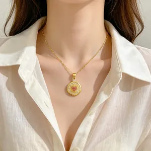 Nahaufnahme einer eleganten goldenen Herzhalskette an einem Modell in weißer Bluse