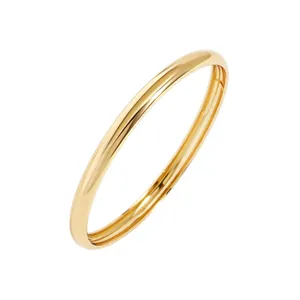 Primer plano de un brazalete minimalista de metal dorado pulido espejo abierto para mujer.