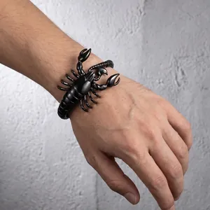 Detailed view of a bold black scorpion-shaped titanium steel bracelet worn on a male wrist.