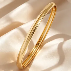 Primer plano detallado de un brazalete abierto dorado con acabado de espejo pulido