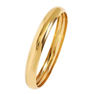 Vista detallada de un brazalete de oro pulido con un acabado de espejo brillante y banda.