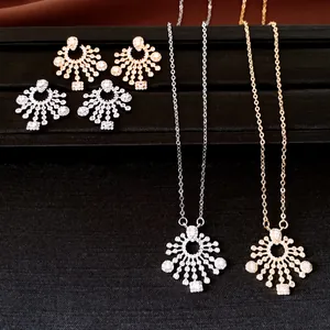 Close-up of sparkling sunburst zirconia necklace and earring set in silver and gold