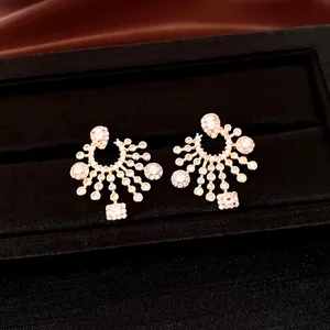 Macro view of luxury golden zircon stud earrings with radiant drop design in black gift box