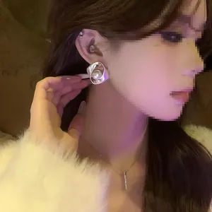 Mannequin portant des boucles d'oreilles perles en argent au style minimaliste et sophistiqué