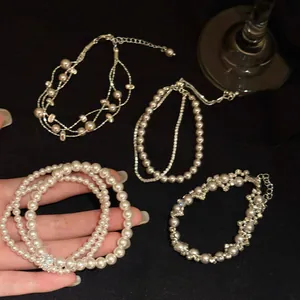 Detailopname van elegante parelarmbanden in Franse stijl met zirkoon en geometrie