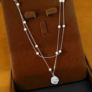 Elegante collar de doble capa con perlas pequeñas y un brillante colgante de flor de circón