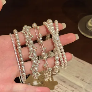 Detailopname van verschillende elegante parel- en zirkoonarmbanden in Franse vintage-stijl