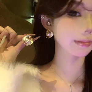 Détail élégant de boucles d'oreilles rondes torsadées avec perle et tige en argent