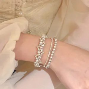 Detailopname van een elegante meerlaagse armbandset in Franse stijl met zirkonia en parels