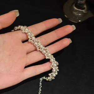 Gedetailleerd zicht op een elegante Franse stijl zirkoon en parel armband op de hand