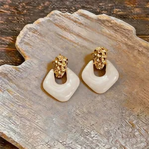 Boucles d'oreilles rétro avec haut en or martelé et pendentif en résine marbrée crème