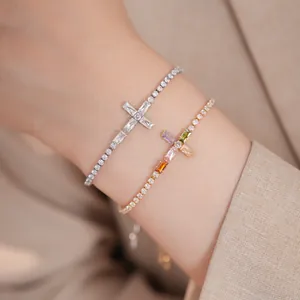 Λεπτομέρεια από επιχρυσωμένα βραχιόλια 18k με λαμπερούς σταυρούς από ζιργκόν.