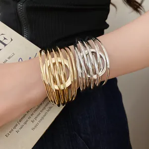 Gros plan de bracelets multi-rangs dorés et argentés entrelacés sur le poignet