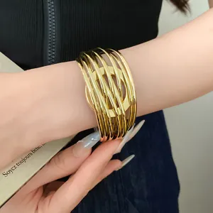 Détail d'un large bracelet doré à plusieurs rangs entrelacés avec une finition brillante