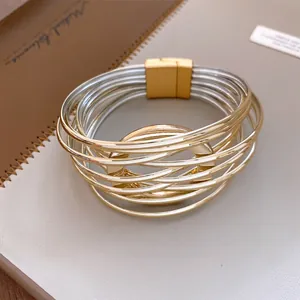 Zoom sur un bracelet multi-rangs entrelacé avec fermoir magnétique doré