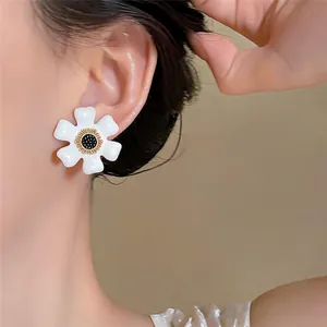Détail d'une boucle d'oreille fleur blanche élégante portée sur l'oreille d'un modèle