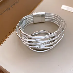 Vue détaillée d'un bracelet multicouche argenté entrelacé avec fermoir magnétique
