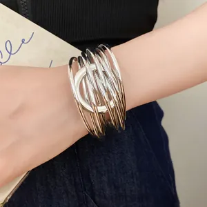 Gros plan d'un bracelet manchette argenté à plusieurs rangs au design circulaire