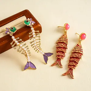 Vue détaillée de boucles d'oreilles créatives en émail en forme de poisson et perles