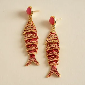 Vue détaillée de boucles d'oreilles poisson en émail rouge et perles roses dorées.
