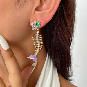 Détail d'une boucle d'oreille créative en arête de poisson avec émail et perles