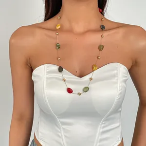 Detailansicht einer bunten Acryl-Perlenkette, getragen von einem weiblichen Model in Weiß