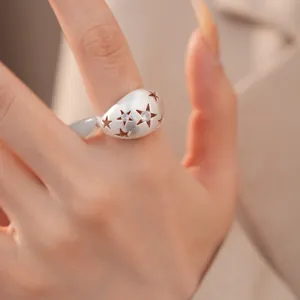 Detail van een geborstelde zilveren ovale ring met sterren en zirkonia steentjes