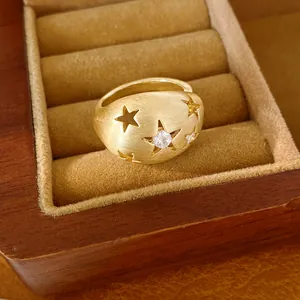 Detailweergave van een geborstelde gouden sterring met zirkoon in een houten doos