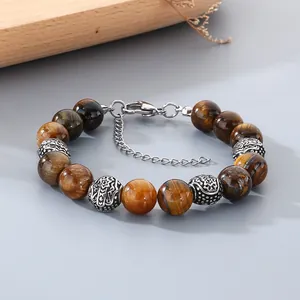 Close-up detail of tiger eye beads and engraved stainless steel accents on a beaded bracelet