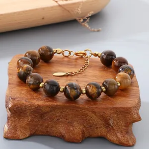 Close-up detail of polished tiger eye stone beads on a vintage gold stainless steel bracelet