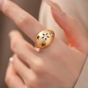 Detail van een gouden geborstelde ring met uitgesneden sterren en zirkoon