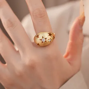 Detailopname van een gouden ovale ring met geborstelde afwerking en ster-zirkonia inlays