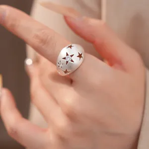 Macrodetail van een geborstelde zilveren ovale ring met zirkonia ster-uitsparingen