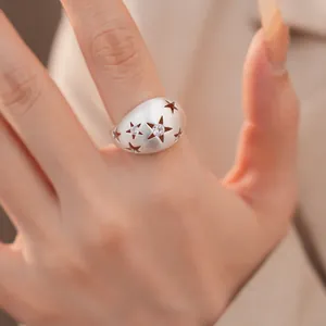 Detailweergave van een geborstelde zilveren ring met uitgesneden sterren en zirkonia.