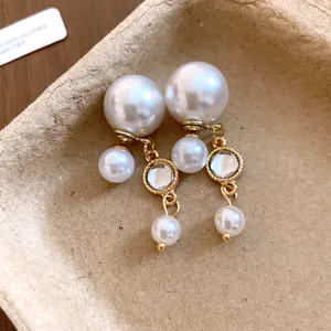Close-up detail of elegant pearl tassel earrings with gold-toned finish and clear resin