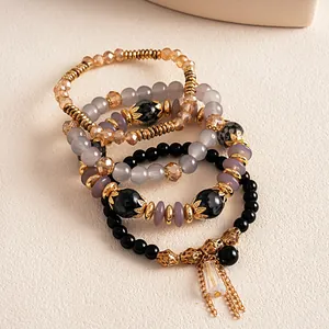 Detalle de un juego de 4 pulseras étnicas vintage de cuentas con borlas doradas y cristales