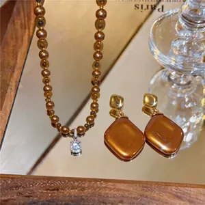 Vintage braunes Perlenhalsketten-Set mit Kristallanhänger und passenden Rautenohrringen