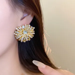 French vintage gold-tone flower stud earrings featuring white pearls and rhinestones.