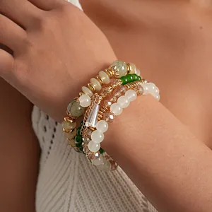 Vista detallada de un conjunto de cuatro pulseras bohemias de cuentas vintage en la muñeca