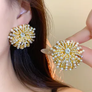 Detailed view of vintage floral stud earrings featuring pearls and rhinestones on gold base.