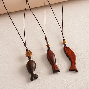 Close-up of ethnic style wooden fish pendants with handcrafted brown woven cords