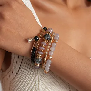 Primer plano de un conjunto de cuatro pulseras vintage bohemias de cuentas en la muñeca