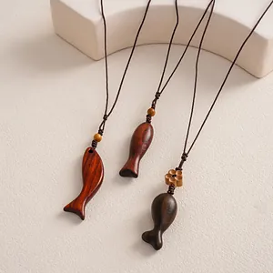 Macro view showing the natural wood grain and textures of ethnic fish-shaped pendants