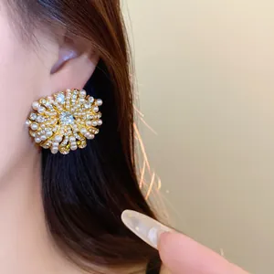 Close-up of French vintage style floral stud earrings with pearls and crystals