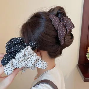 Gedetailleerde weergave van een Koreaanse haarscrunchie en haarklem met bloemenprint.